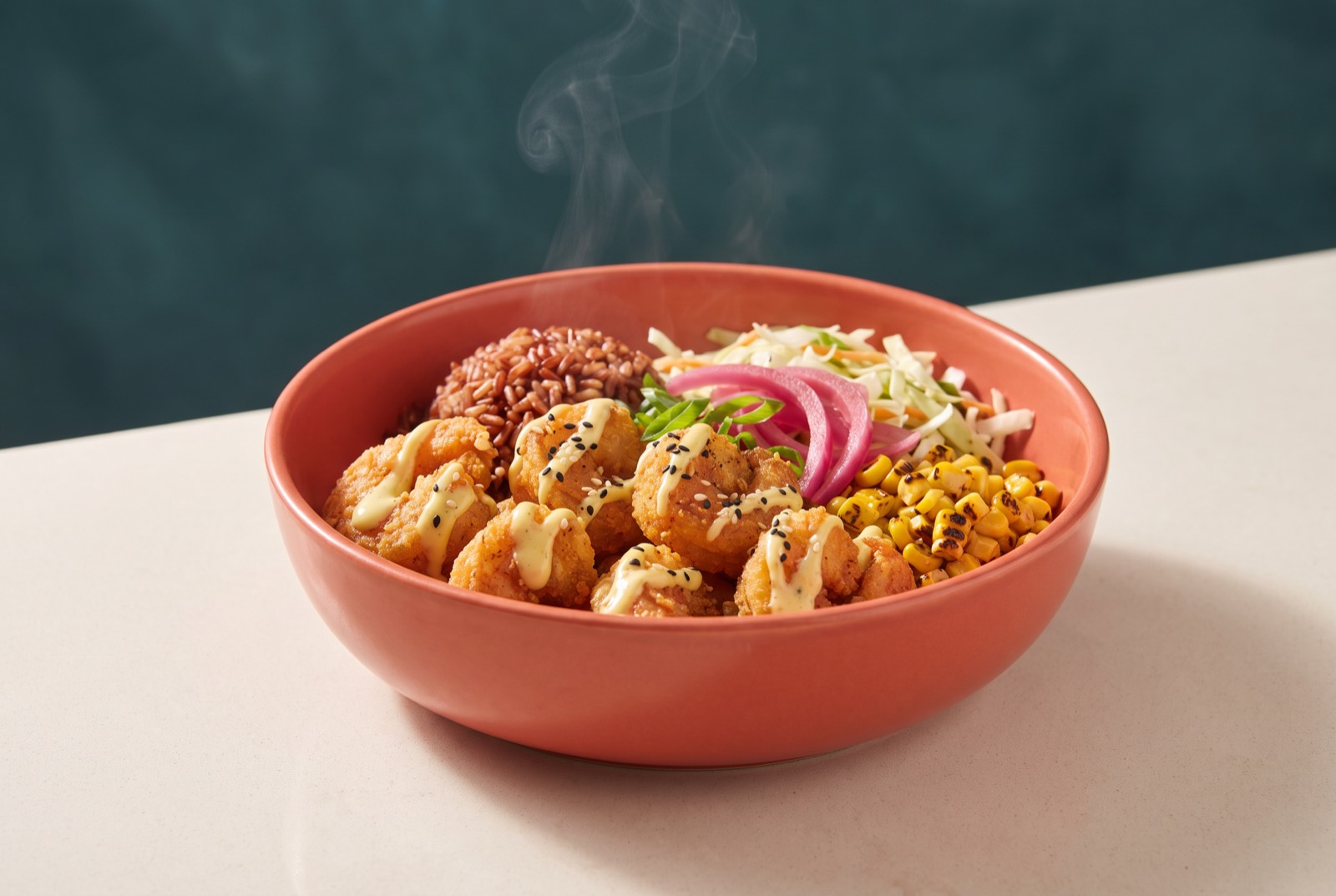 Steaming coral bowl of crispy shrimp, red rice, corn, and pickled onion
