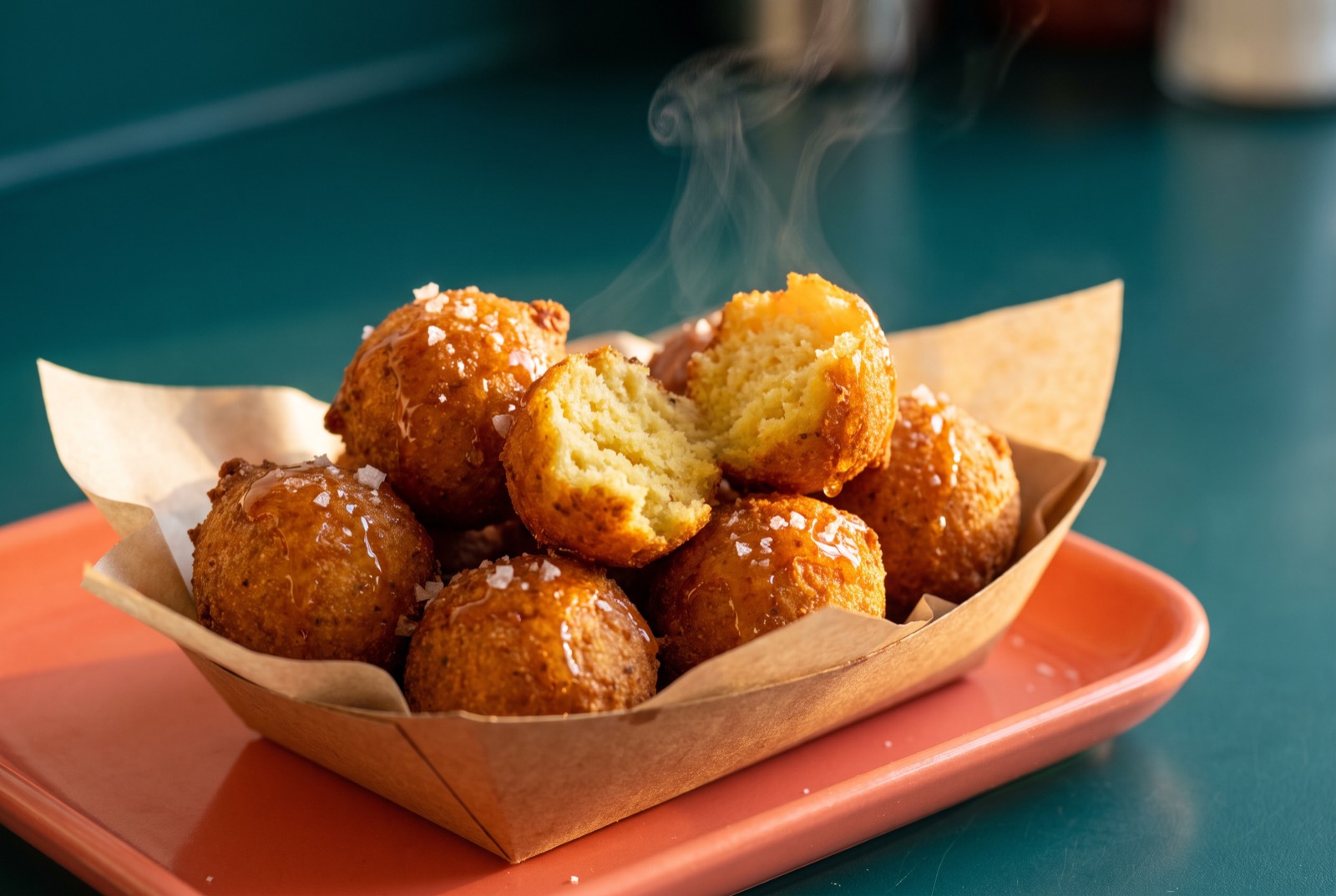 Hush puppies with hot honey on a coral tray