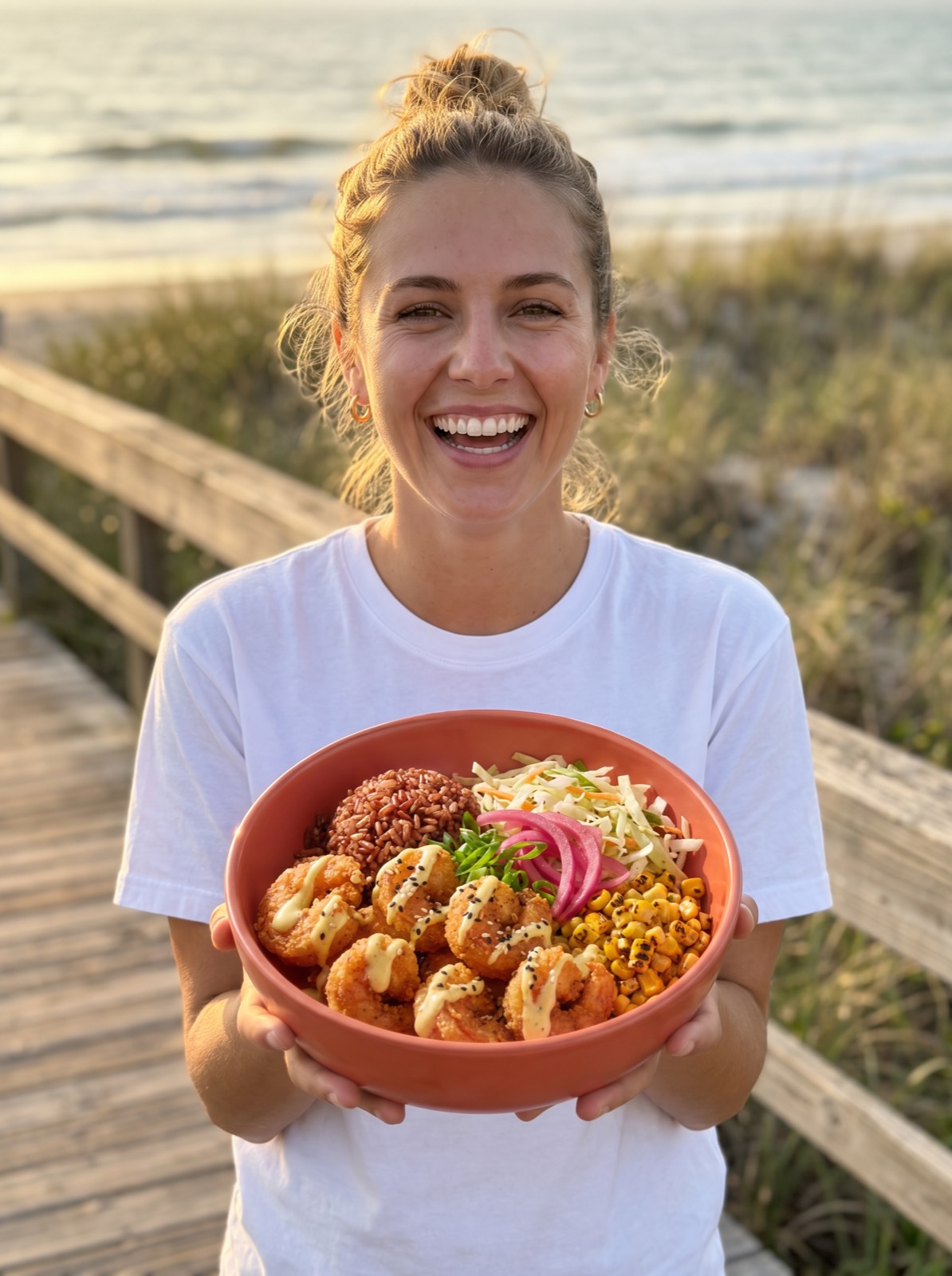 Laughing customer holding a Castnet bowl on a beach boardwalk at golden hour