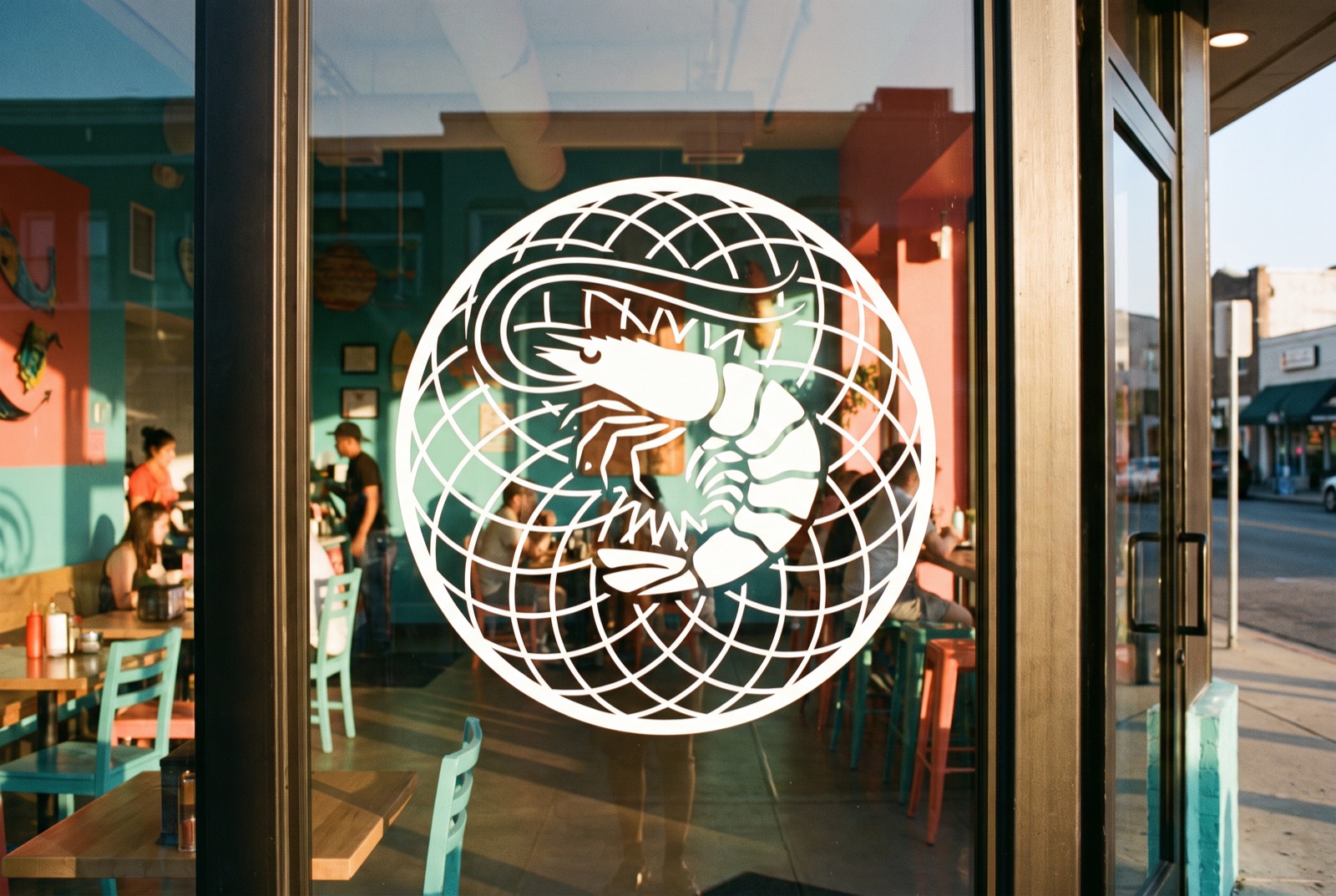 Die-cut shrimp-in-net vinyl roundel on the storefront glass