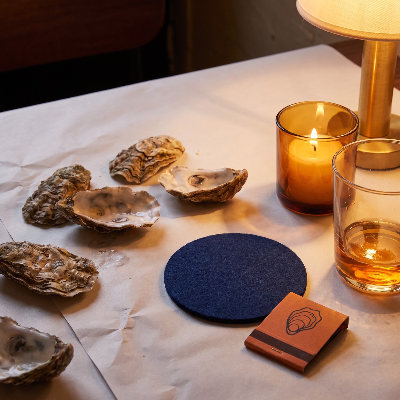 Butcher paper table covering with navy coaster and ember matchbook
